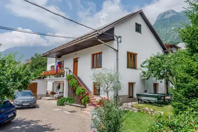 a white house with a car parked in the driveway at Apartments Wojcicky in Bovec