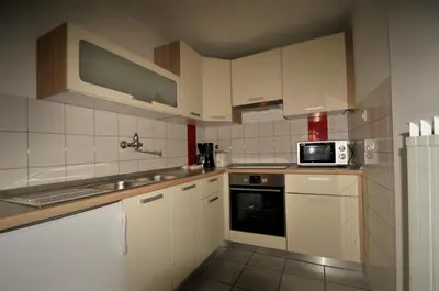 a kitchen with white cabinets and a microwave at Apartments Wojcicky in Bovec