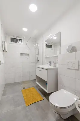 a white bathroom with a toilet and a sink at Apartments Wojcicky in Bovec