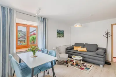 a living room with a couch and a table and chairs at Apartments Wojcicky in Bovec