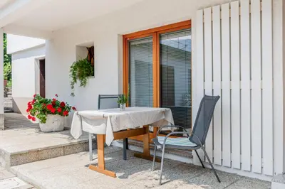 a table and chairs sitting outside of a house at Apartments Wojcicky in Bovec
