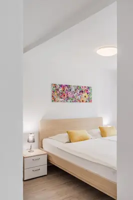 a bedroom with a bed and a painting on the wall at Apartments Wojcicky in Bovec