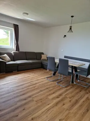 a living room with a couch and a table and chairs at Apartmaji Pr Ambružarju in Cerklje na Gorenjskem