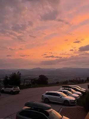a row of cars parked in a parking lot at sunset at Apartmaji Pr Ambružarju in Cerklje na Gorenjskem