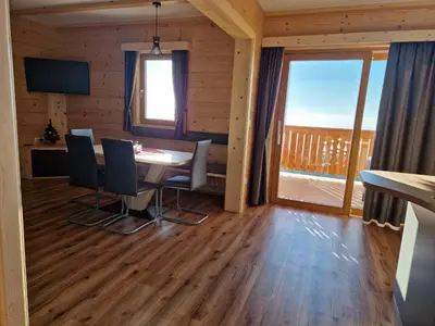 a dining room with a table and chairs and a large window at Apartmaji Pr Ambružarju in Cerklje na Gorenjskem