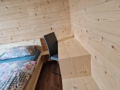 a room with a bed and a desk and a chair at Apartmaji Pr Ambružarju in Cerklje na Gorenjskem