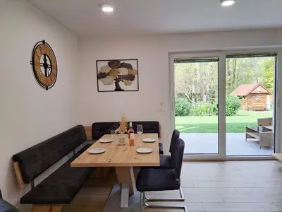 a dining room with a table and a couch at Apartments Zlati Rog in Kranjska Gora