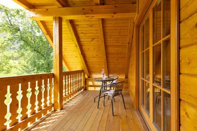 a wooden porch with a table and chairs on it at Apartma Brunarca in Borovnica