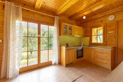 a kitchen with wooden cabinets and a large window at Apartma Brunarca in Borovnica