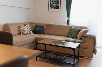 a living room with a brown couch and a table at Vista Apartment in Sveta Trojica v Slovenskih Goricah