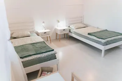 two beds in a room with two night stands and two tables at Vista Apartment in Sveta Trojica v Slovenskih Goricah