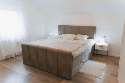 a large bed in a bedroom with a wooden floor at Vista Apartment in Sveta Trojica v Slovenskih Goricah