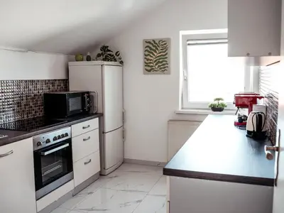 a kitchen with white appliances and a window at Vista Apartment in Sveta Trojica v Slovenskih Goricah