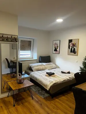 a bedroom with a bed and a couch and a table at Apartmaji MAS 2 in Ljubljana