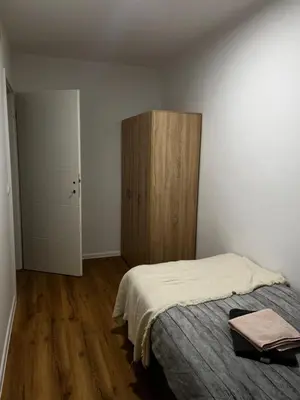 a bedroom with a bed and a wooden cabinet at Apartmaji MAS 2 in Ljubljana
