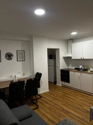 a living room with a kitchen and a table and chairs at Apartmaji MAS 2 in Ljubljana