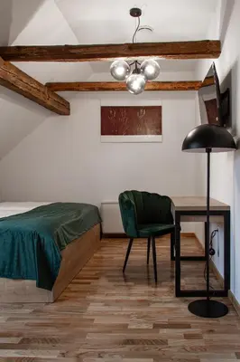 a bedroom with a bed and a table and a chair at Gostišče Pod Kostanji in Dobrna