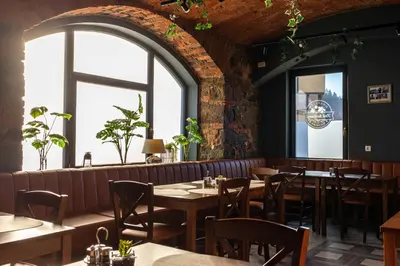 a restaurant with tables and chairs and windows at Gostišče Pod Kostanji in Dobrna