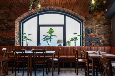 a dining room with tables and chairs and a large window at Gostišče Pod Kostanji in Dobrna
