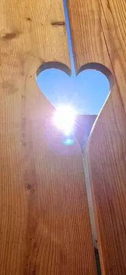a view of the sun through a wooden table at Poku bajka in Kranjska Gora
