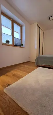an empty room with a bed and two windows at Poku bajka in Kranjska Gora