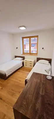 a bedroom with two beds and a wooden floor at Poku bajka in Kranjska Gora