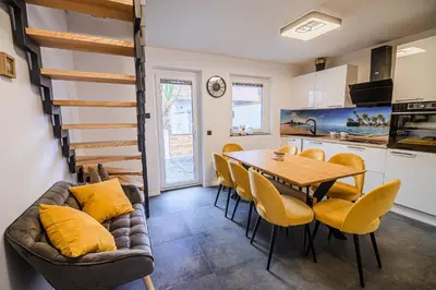 a kitchen and dining room with a table and chairs at Holiday Home Villa Rio in Terme Čatež in Čatež ob Savi