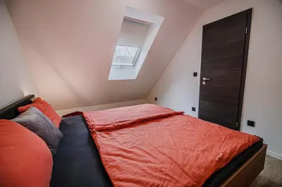 a bedroom with a bed with red sheets and a window at Holiday Home Villa Rio in Terme Čatež in Čatež ob Savi