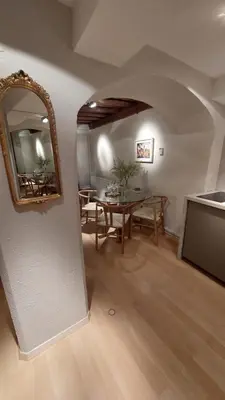 a living room with a table and a mirror at Bartolomeo Apartment in Ljubljana