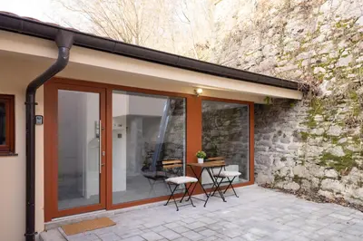 a house with sliding glass doors and a stone wall at Apartments Napoleon in Ljubljana
