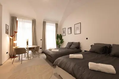 a bedroom with two beds and a table in it at Apartments Napoleon in Ljubljana
