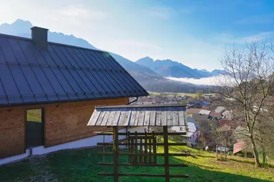 a house with a metal roof on top of a hill at Alpine Retreat house Šurc in Rateče