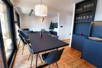 a dining room with a black table and chairs at Alpine Retreat house Šurc in Rateče