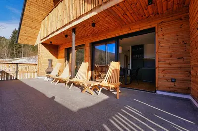 a group of chairs sitting on the outside of a building at Alpine Retreat house Šurc in Rateče