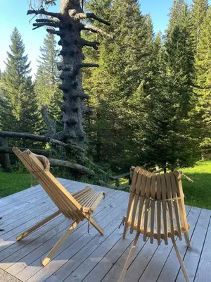 a hammock and a chair on a wooden deck at New cosy apartment in nature - Krvavec in Cerklje na Gorenjskem