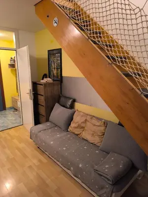 a couch in a living room with a staircase at Apartma Dian in Mostec