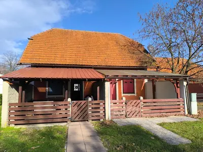 a small house with a fence and a red roof at Apartma Dian in Mostec