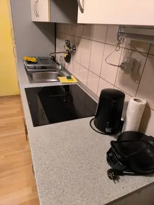 a kitchen counter with a sink and a black stool at Apartma Dian in Mostec