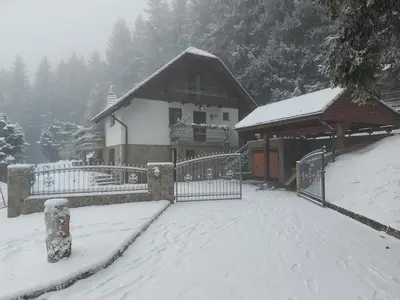 a house with a gate and a snow covered yard at Apartma Escales -naselje Nune-Rogla in Zreče