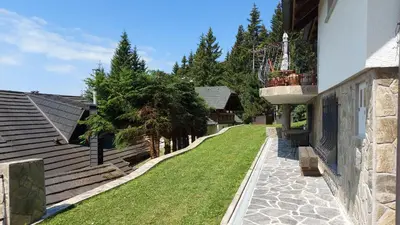 a walkway next to a building with a green yard at Apartma Escales -naselje Nune-Rogla in Zreče