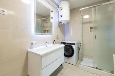 a bathroom with a sink and a washing machine at Apartment Pohorje Sun - Entire house in Maribor