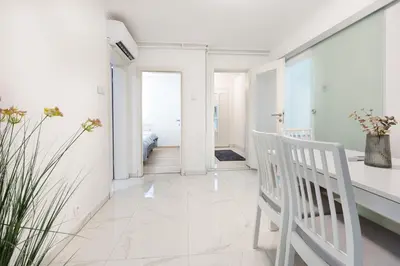 a white hallway with a white chair and a bedroom at Apartment Pohorje Sun - Entire house in Maribor