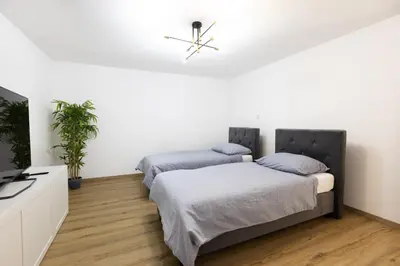 two beds in a room with white walls at Apartment Pohorje Sun - Entire house in Maribor