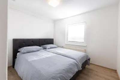 a bedroom with a large bed with a window at Apartment Pohorje Sun - Entire house in Maribor
