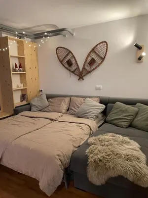 a bedroom with a bed and a couch with a heart on the wall at New cosy apartment, smučišče Krvavec in Cerklje na Gorenjskem