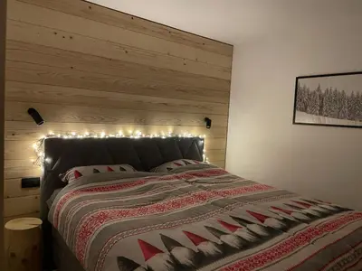 a bedroom with a large bed with lights on it at New cosy apartment, smučišče Krvavec in Cerklje na Gorenjskem