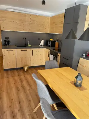 a kitchen with a wooden table and chairs at New cosy apartment, smučišče Krvavec in Cerklje na Gorenjskem