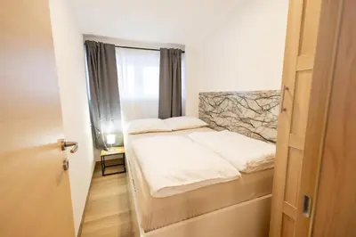 a small bedroom with a bed and a window at Hozi House -4 cozy apartment's in Ljubljana