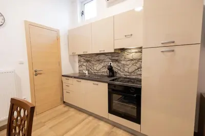 a kitchen with white cabinets and a stove top oven at Hozi House -4 cozy apartment's in Ljubljana