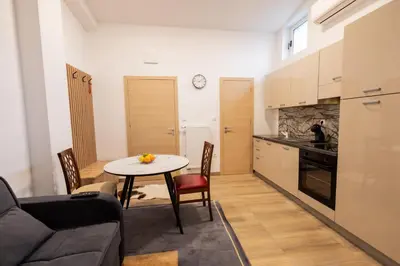 a living room with a table and a kitchen at Hozi House -4 cozy apartment's in Ljubljana
